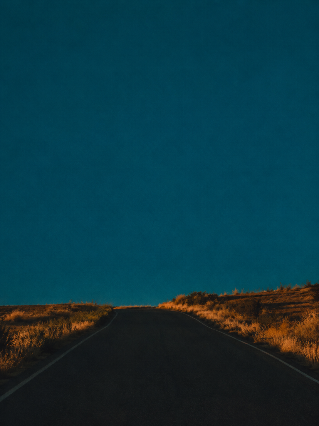 An open road beneath a deep blue sky